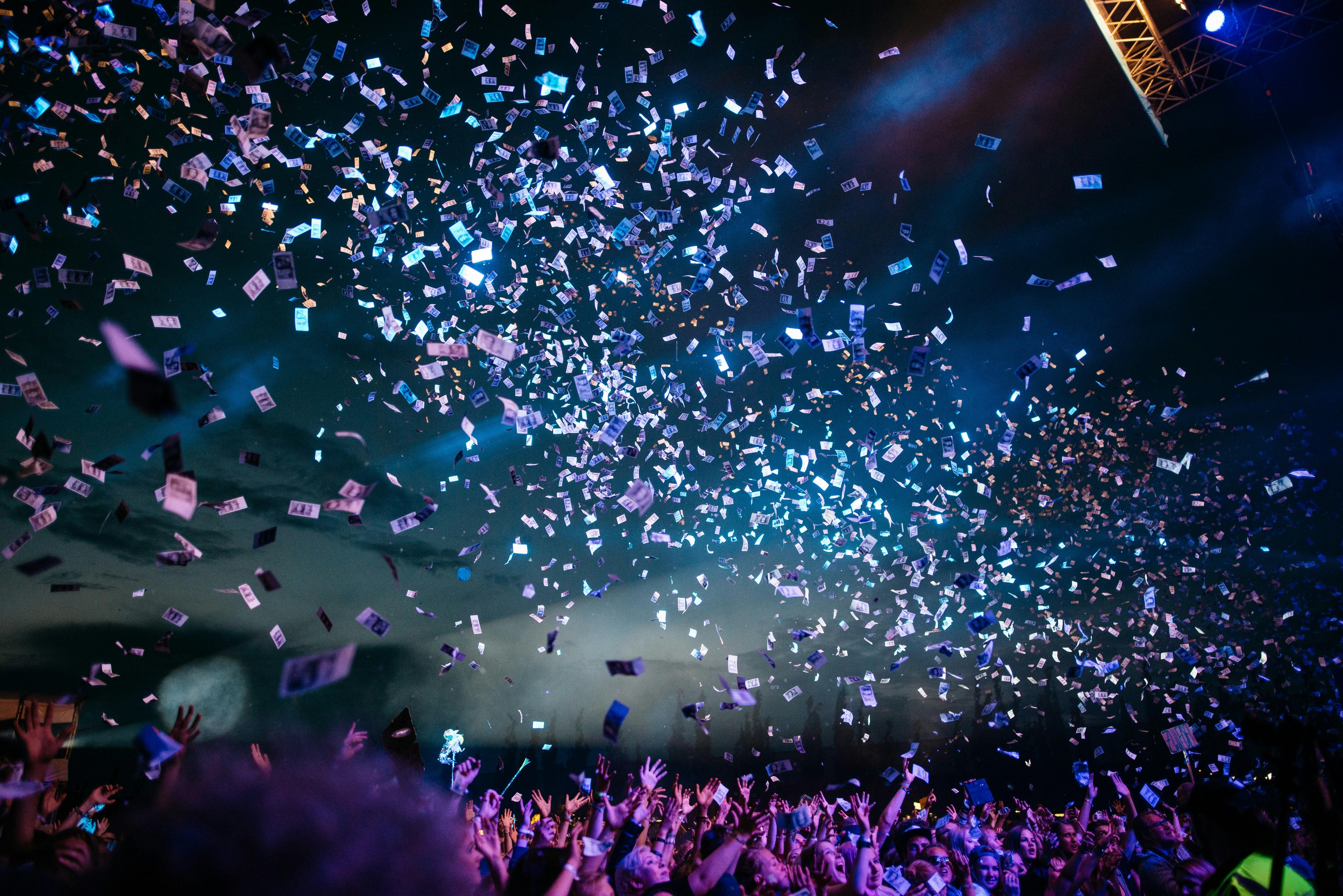 Excited crowd at event with confetti falling